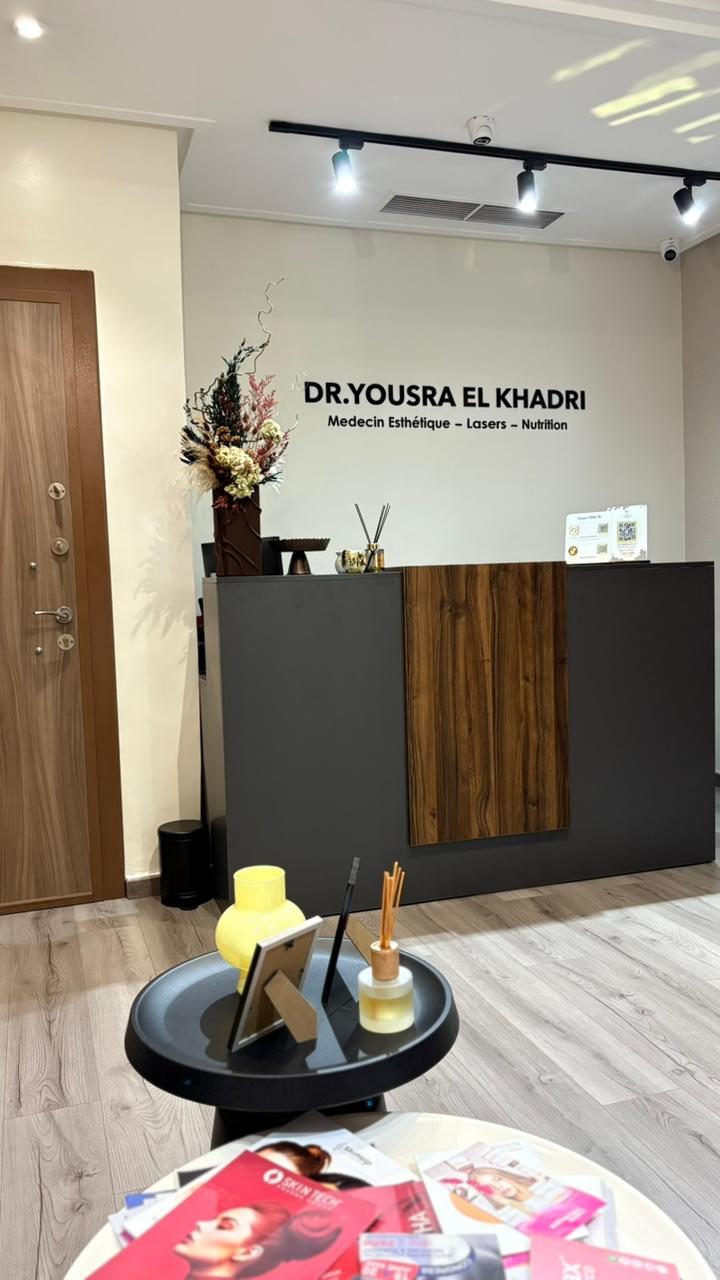 Espace d'accueil du cabinet de médecine esthétique Dr Yousra El Khadri à Casablanca, ambiance cosy avec mur en bois noyer et logo signature